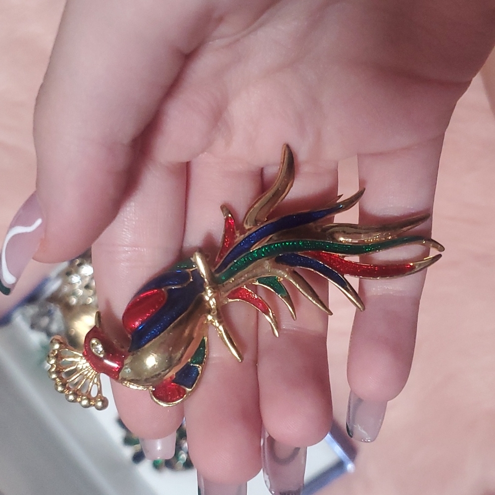 Multicoloured peacock brooch.